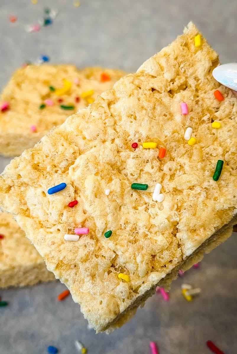 Close up of soft and chewy protein Rice Krispie treat topped with colorful sprinkles.