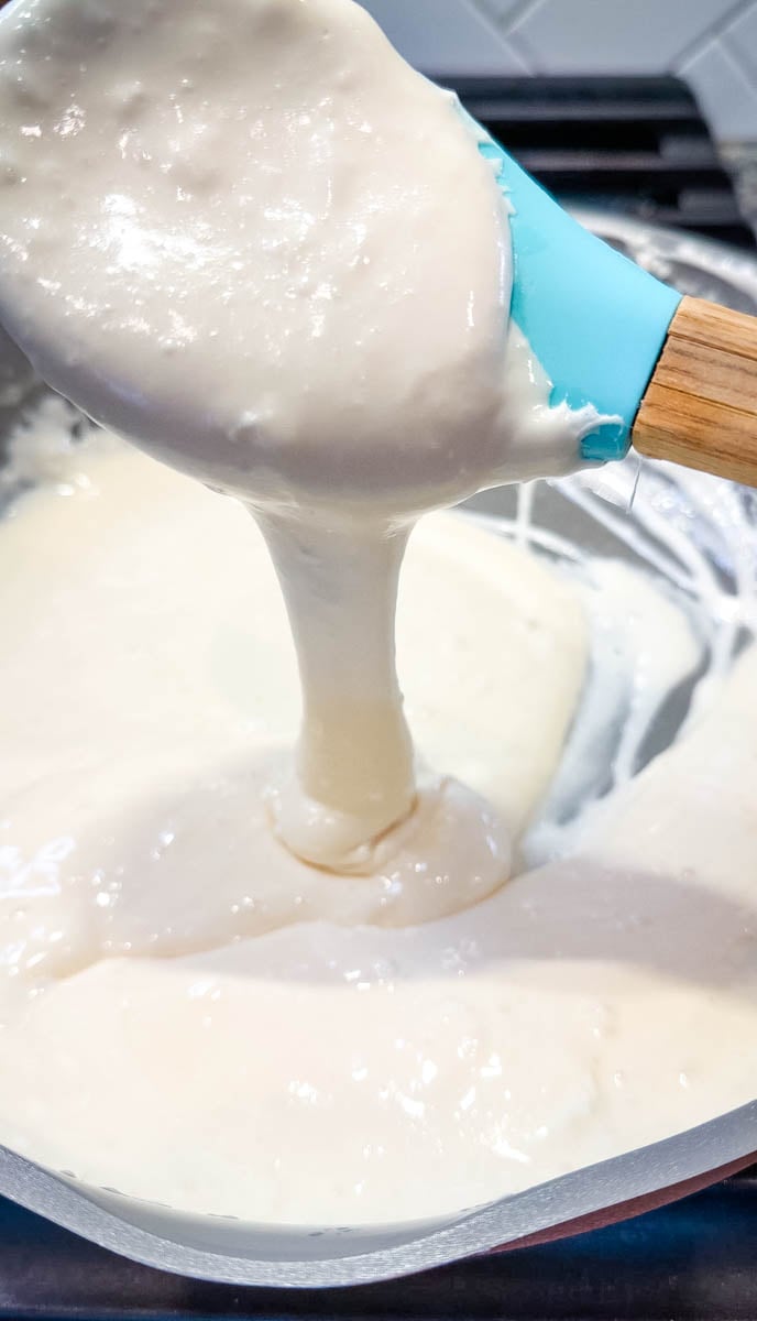 Melted marshmallow mixture with butter and milk stirred until smooth and creamy for protein Rice Krispie treats.