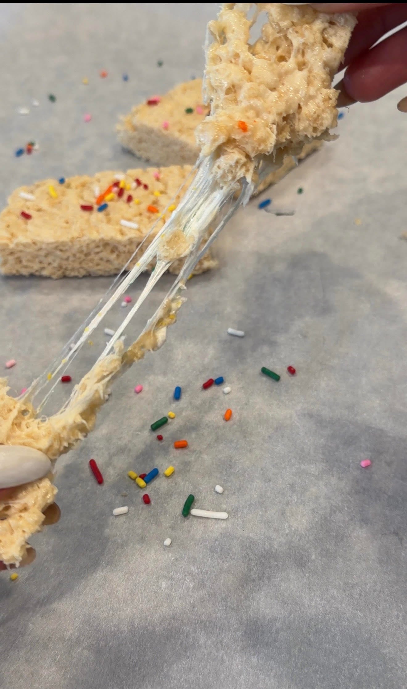 person pulling apart gooey protein Rice Krispie treat