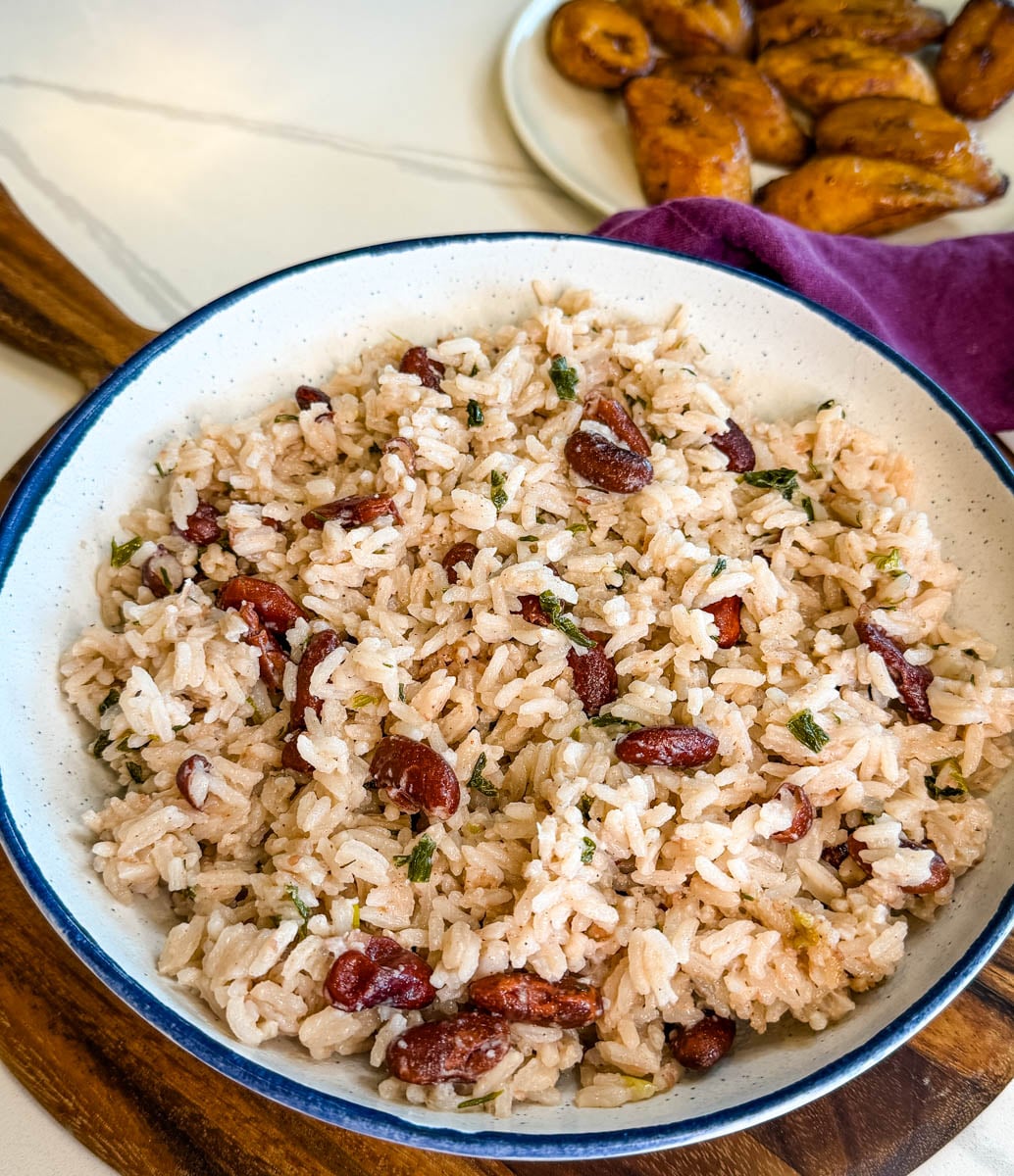 Close-up of fluffy Jamaican rice and peas showing tender grains, red kidney beans, and herbs mixed throughout.