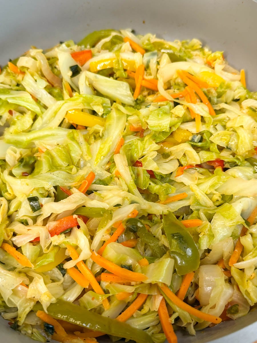 Close-up of Jamaican steamed cabbage with tender cabbage, sliced bell peppers, carrots, and onions sautéed together.
