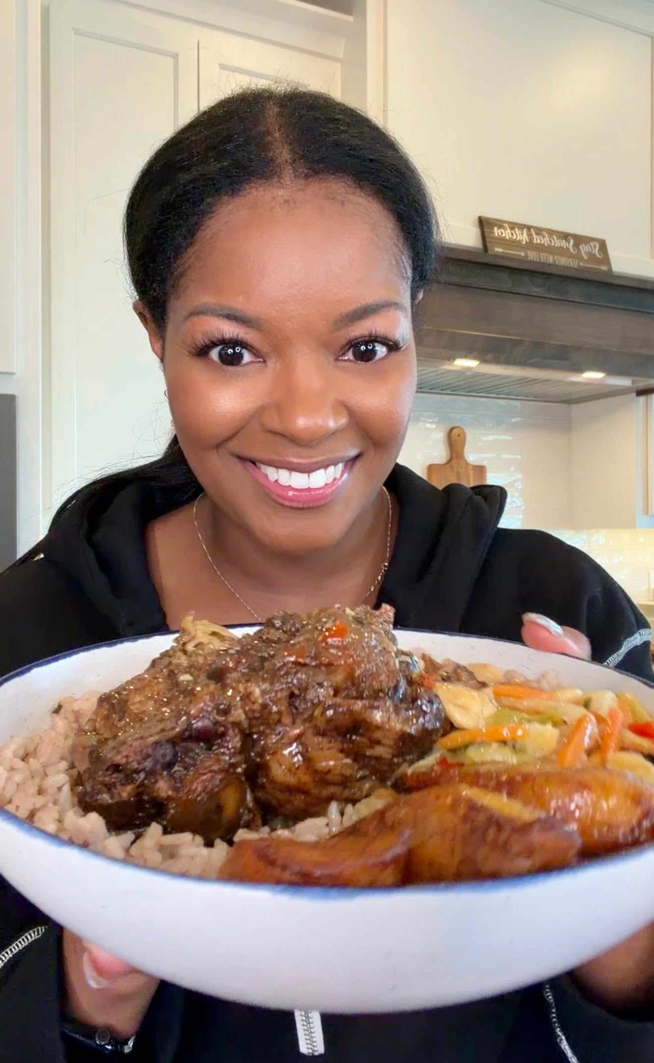 person holding Jamaican oxtail, rice and peas, cabbage, and plantains