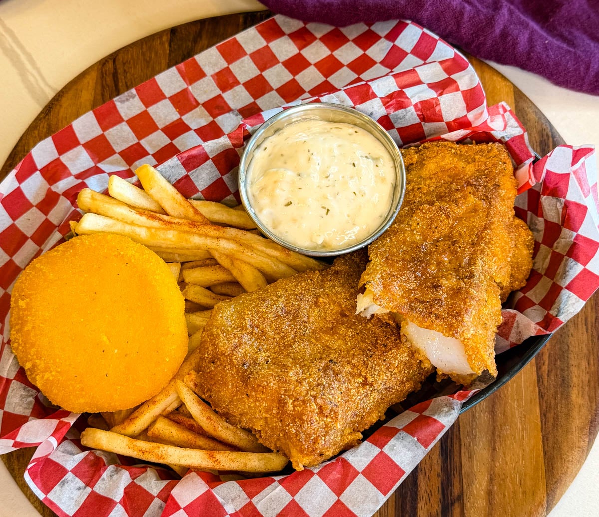 Fried cod basket with crispy fish fillets, seasoned fries, tartar sauce, and hot water cornbread.