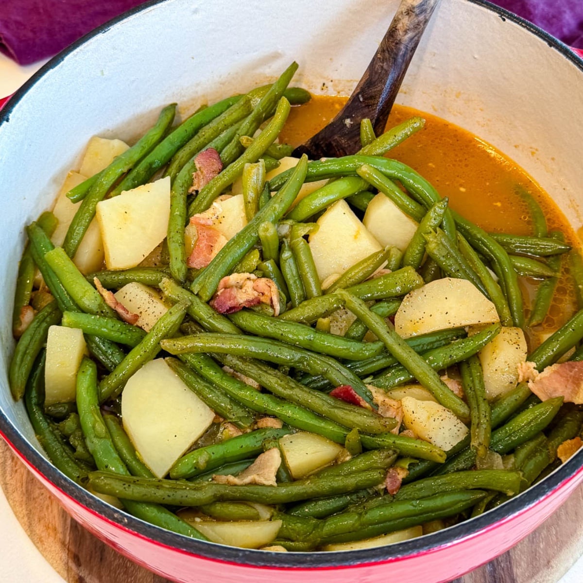 Southern green beans and potatoes cooked with bacon in a savory broth and served in a Dutch oven.