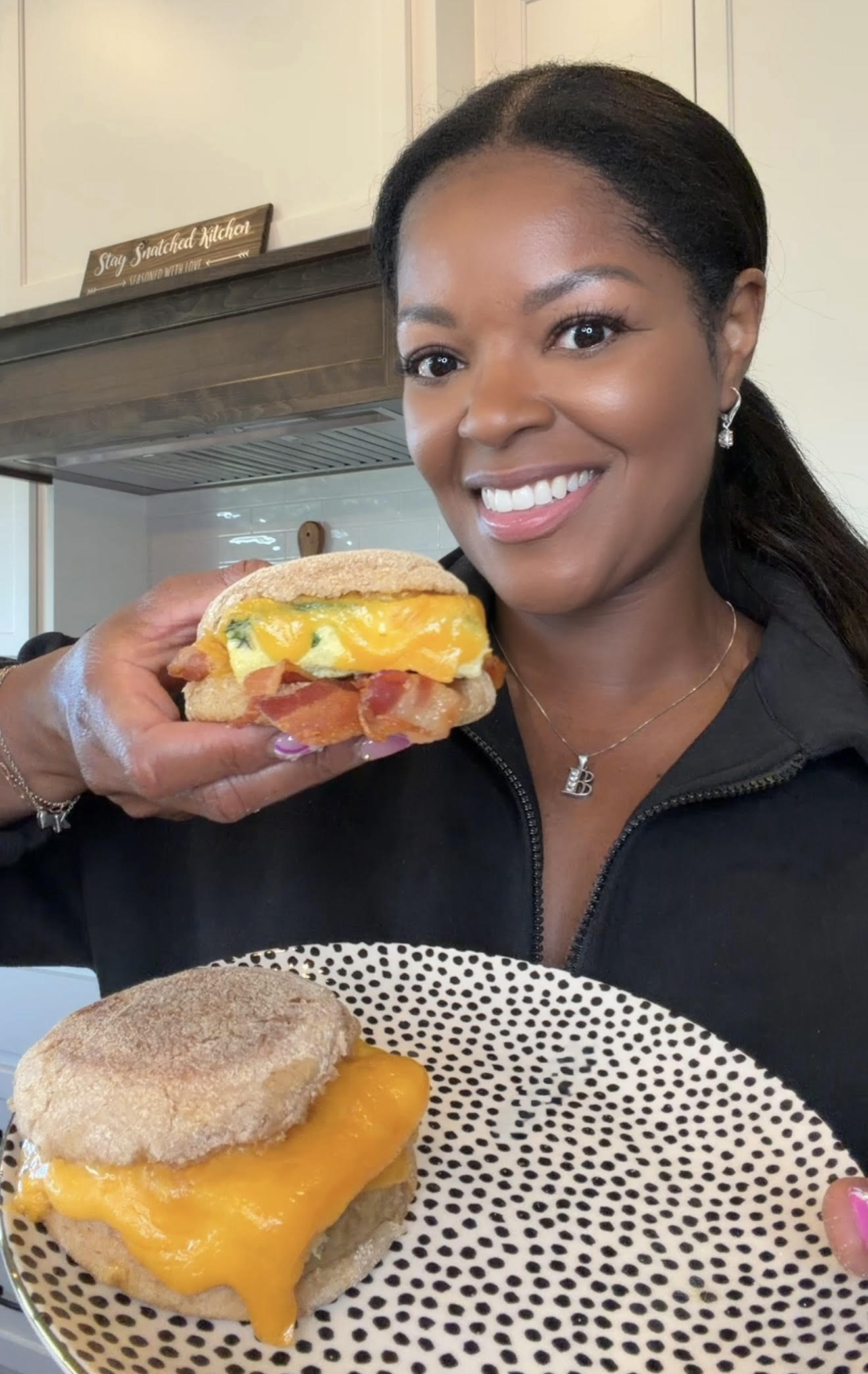 person holding breakfast sandwich with melted cheese