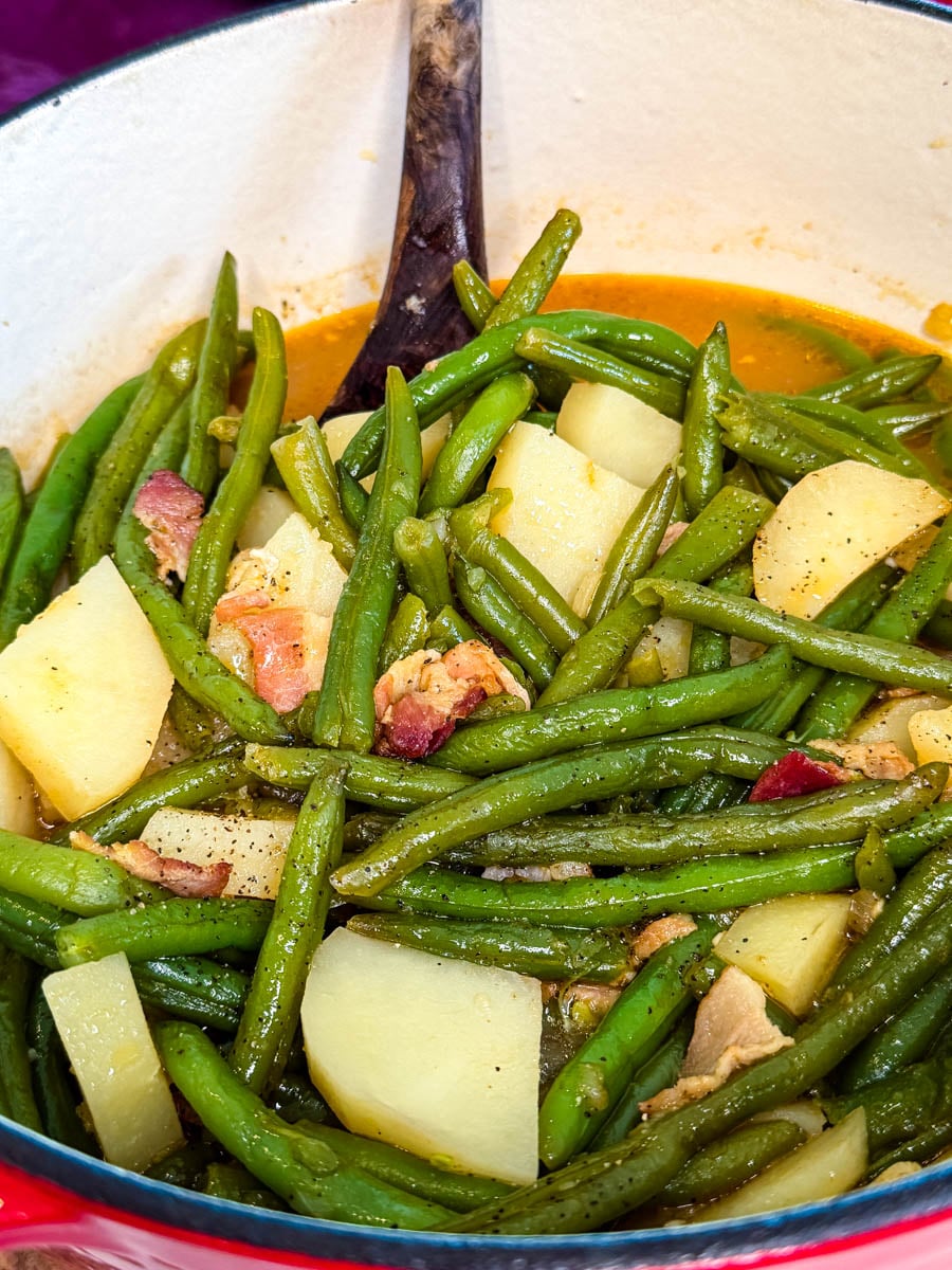 Close-up of tender Southern green beans, potatoes, and bacon simmered in a flavorful seasoned broth.