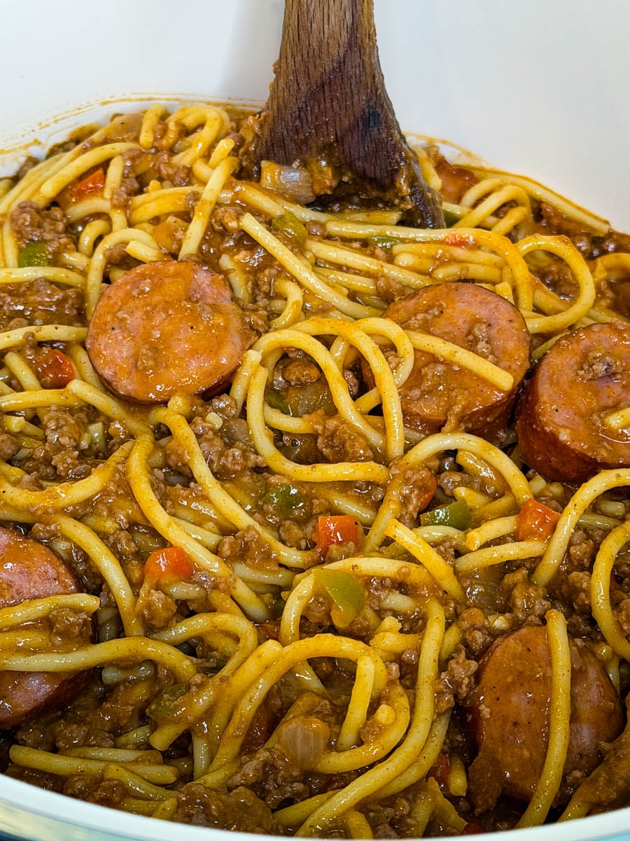 Dirty spaghetti with smoked sausage, seasoned ground beef, onions, and bell peppers tossed together in a rich, savory tomato sauce.