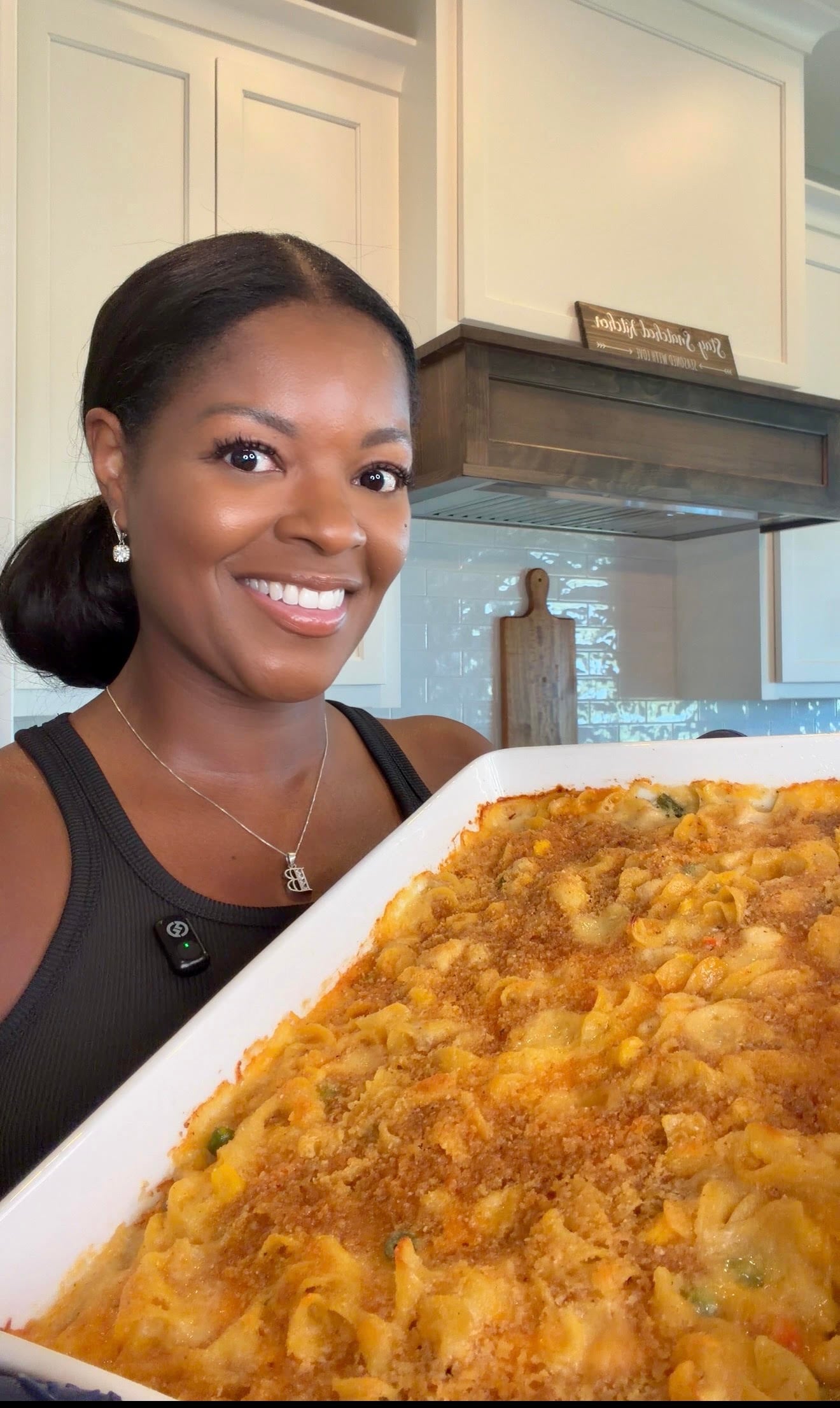Brandi Crawford holding baked chicken noodle casserole in white baking dish