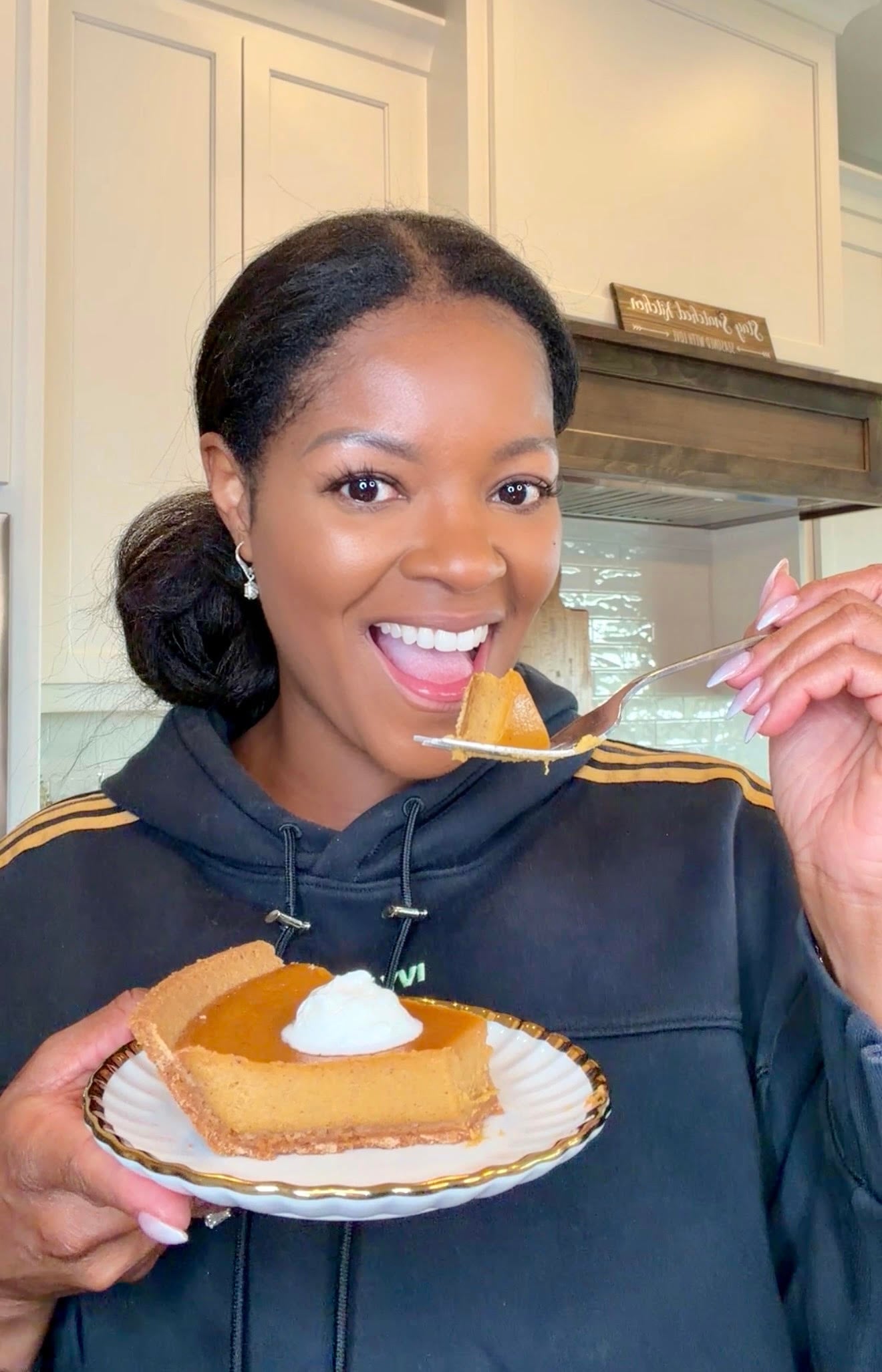Brandi Crawford holding a plate of sweet potato pie with graham cracker crust with a drizzle of whipped cream
