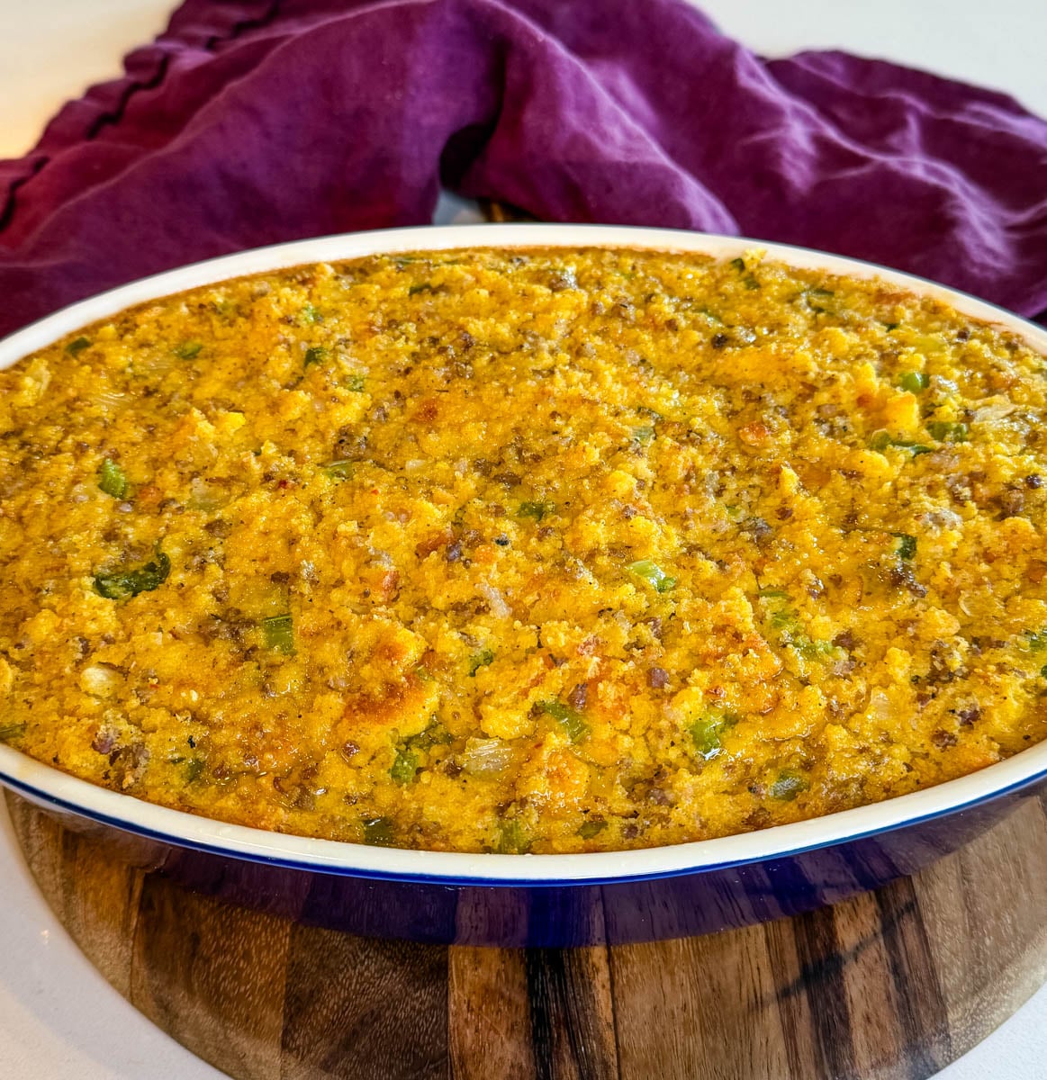 Homemade Southern cornbread dressing with sausage baked until golden brown in an oval casserole dish.