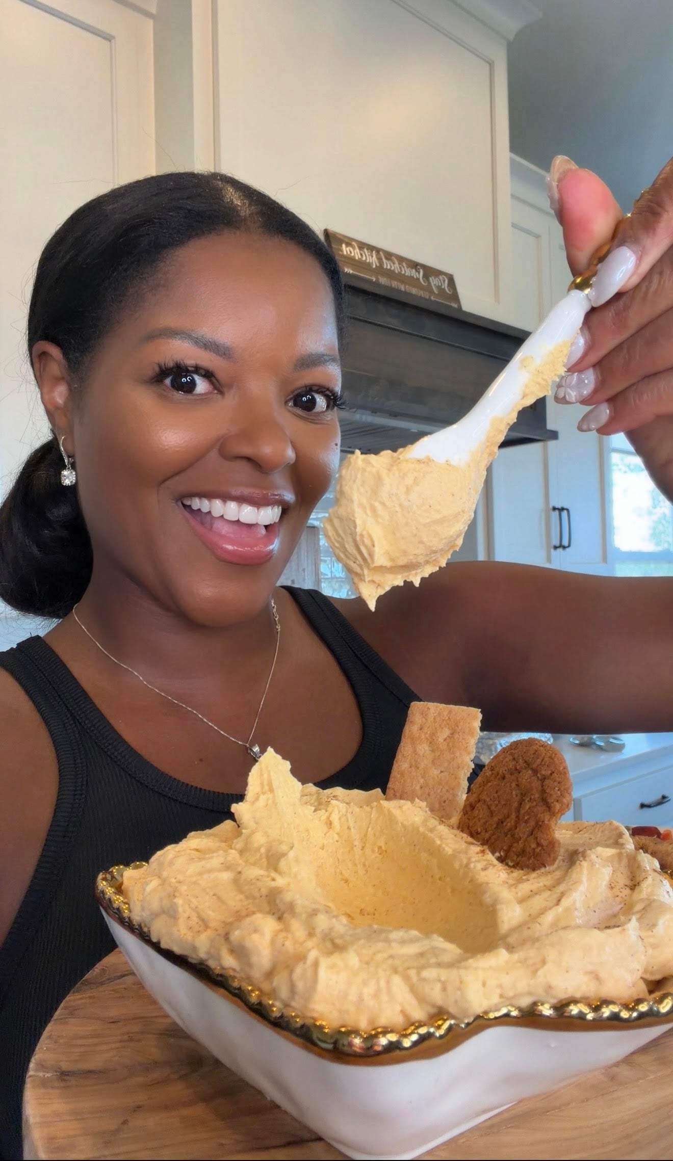 Brandi Crawford holding a spoon full of pumpkin pie cheesecake dip