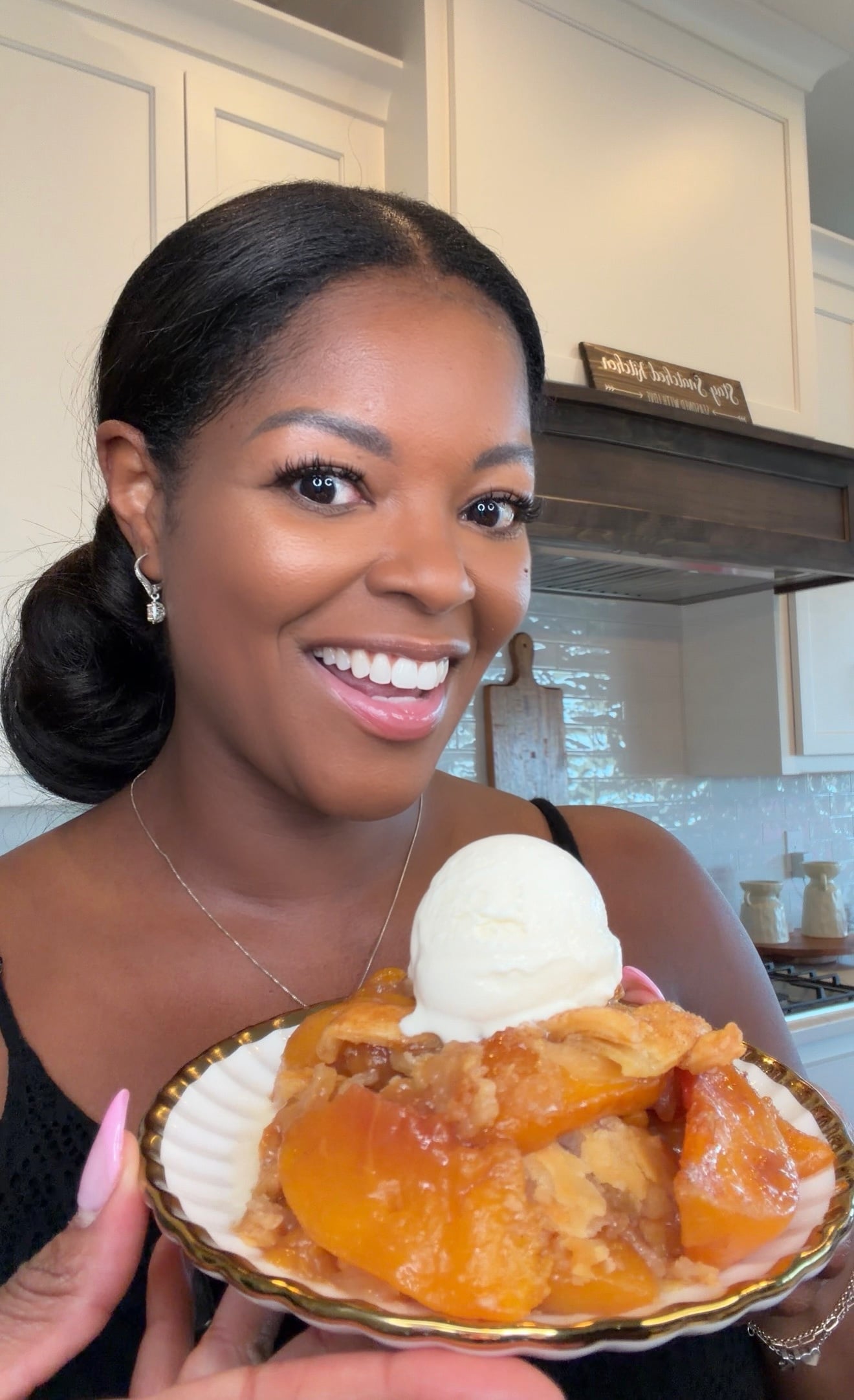 Brandi Crawford holding a slice of Southern peach cobbler with vanilla ice cream