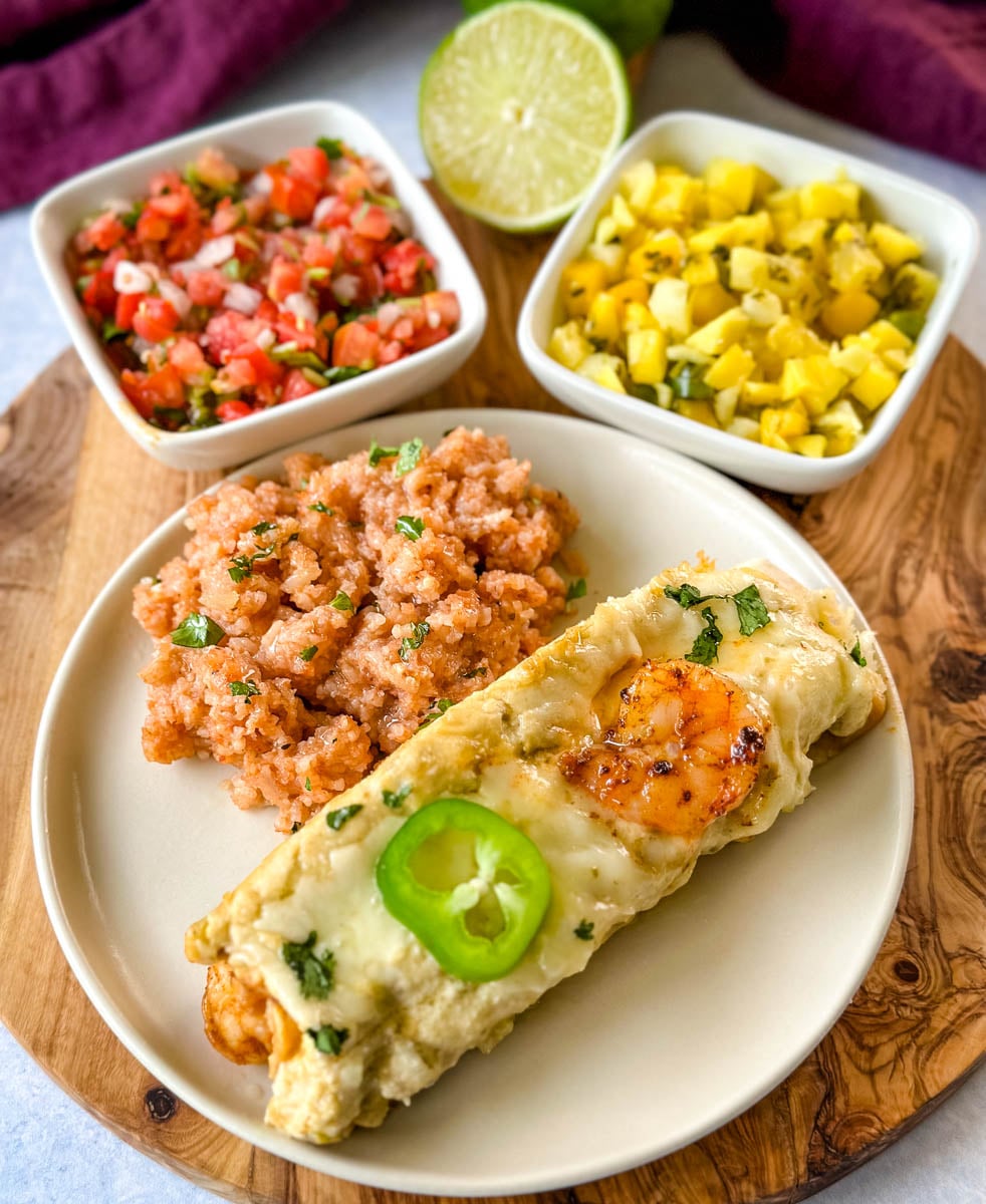 Creamy shrimp enchilada topped with melted cheese, seasoned shrimp, cilantro, and sliced jalapeño, served with Mexican rice, pico de gallo, and fresh salsa.