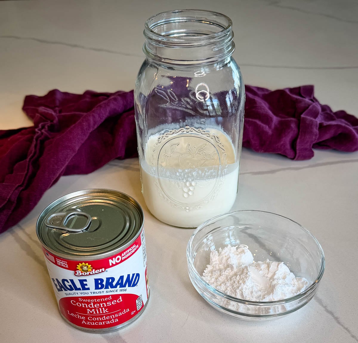 Sweetened condensed milk, milk, and instant pudding mix arranged on a countertop for homemade Chessman banana pudding.
